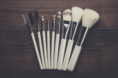 ahşap masa üzerinde beyaz makyaj fırçaları