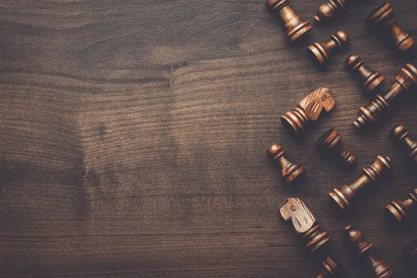 Chess figures on brown wooden table background — Stock Photo, Image