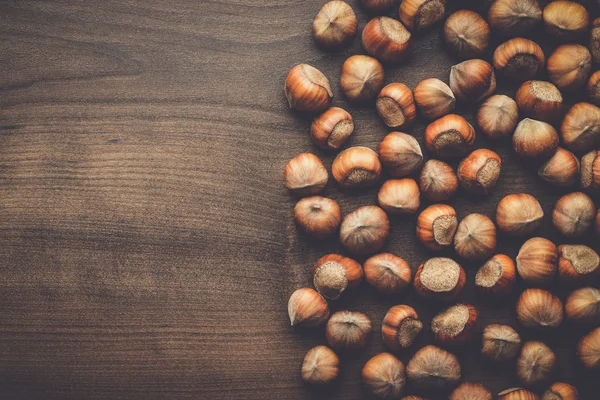 Hasselnötter på brunt trä bordet — Stockfoto