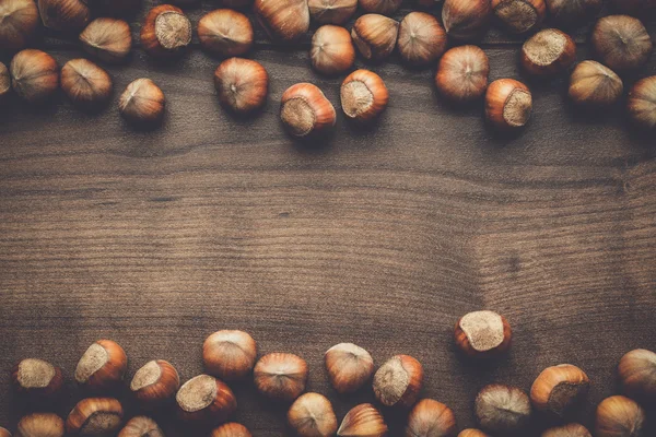 Hasselnötter på brunt trä bordet — Stockfoto
