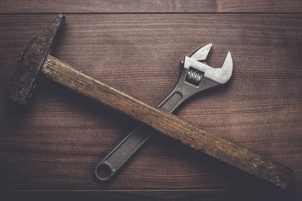 Viejo martillo oxidado y llave inglesa en la mesa — Foto de Stock