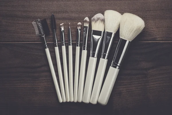 White make-up brushes on wooden table — Stock Photo, Image