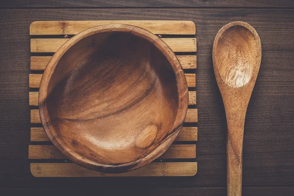 Holzsalatteller und Löffel auf braunem Tisch — Stockfoto