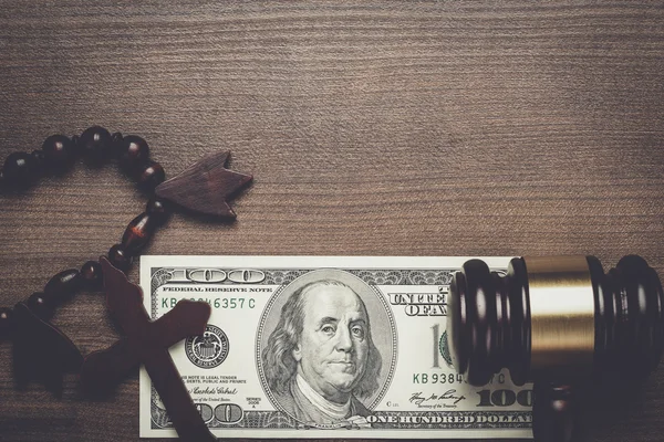 Wooden cross gavel and money on brown table background — Stock Photo, Image