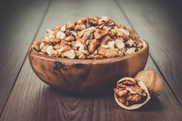 Орехи в коричневой деревянной чаше — стоковое фото