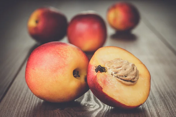 Alcune pesche noci fresche su fondo di legno — Foto Stock