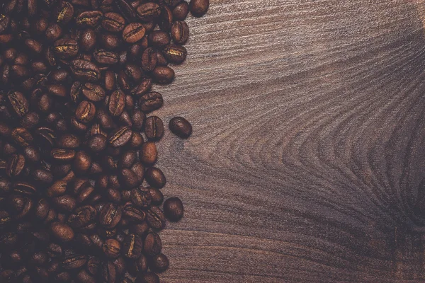 Chicchi di caffè sul tavolo di legno marrone — Foto Stock