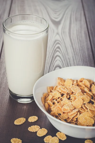 Vaso de leche y tazón con copos de maíz — Foto de Stock