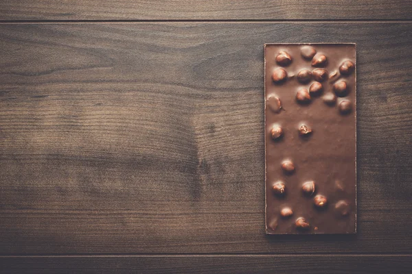 Barra de chocolate con avellanas enteras —  Fotos de Stock