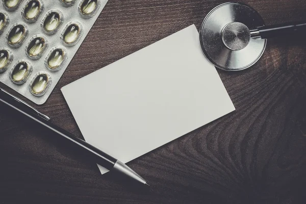 Blank notebook statoscope and pills on the table — Stock Photo, Image