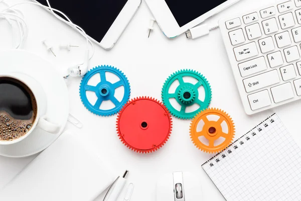 Flusso di lavoro e concetti di lavoro di squadra con ingranaggi colorati e diversi gadget — Foto Stock