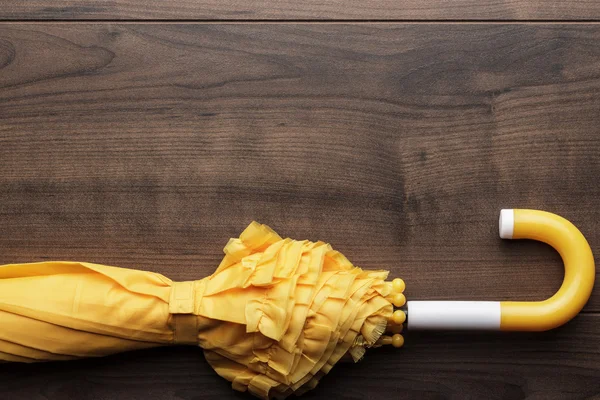 Ombrello giallo piegato sul tavolo — Foto Stock