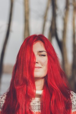 Рыжая женщина, стоящая у реки