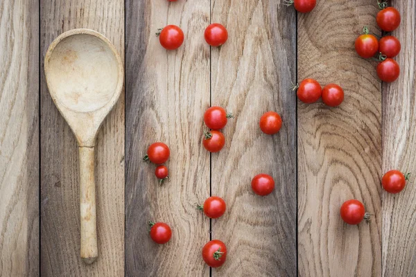 Tomates cereja e colher de madeira — Fotografia de Stock