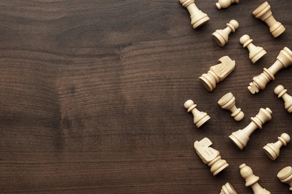 Chess figures on brown wooden table background — Stock Photo, Image