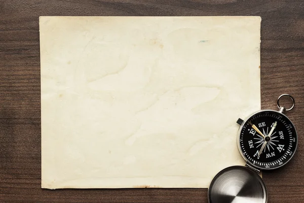 Compass and old paper on the brown wooden table — Stock Photo, Image