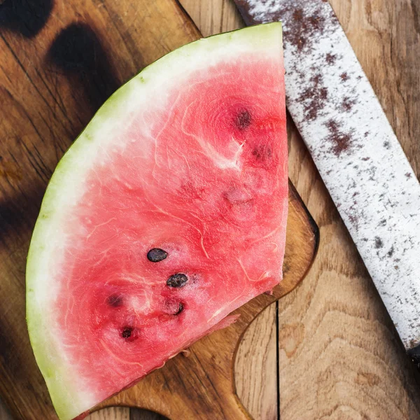 Semangka dan pisau tua di atas meja — Stok Foto