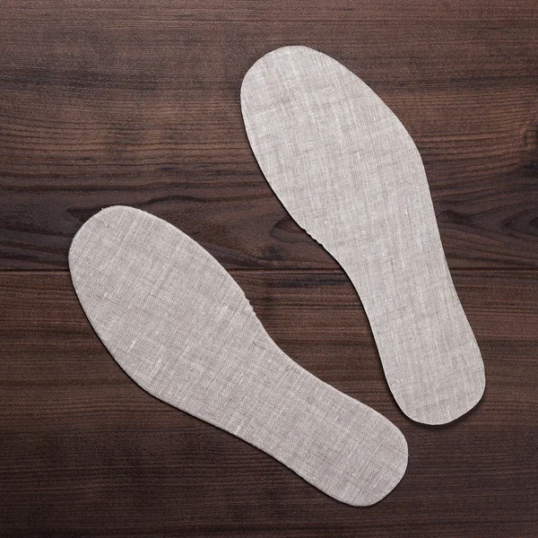 Graue Einlegesohlen für Schuhe auf Holzgrund — Stockfoto