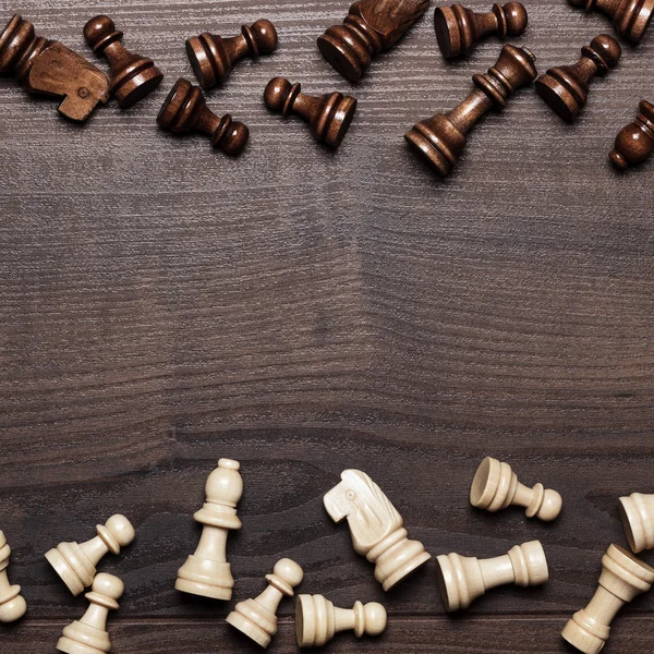 Schackfigurer på brun träbordsbakgrund — Stockfoto