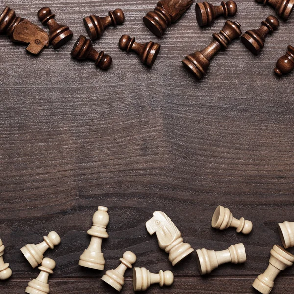 Schaakfiguren op bruine houten ondergrond — Stockfoto