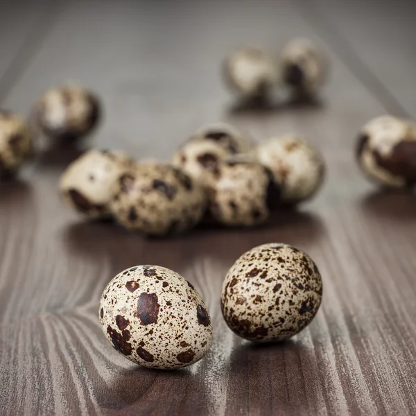 Перепелиные яйца на коричневом деревянном столе — стоковое фото