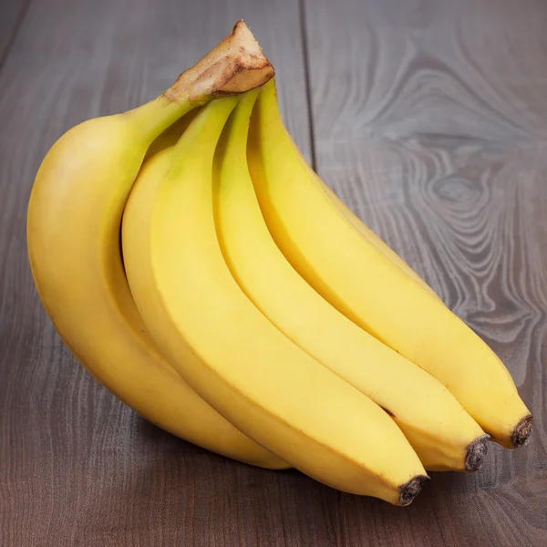 Свежие бананы на коричневом столе — стоковое фото