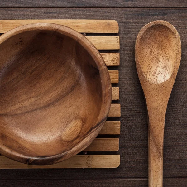 Assiette à salade en bois et cuillère sur table brune — Photo