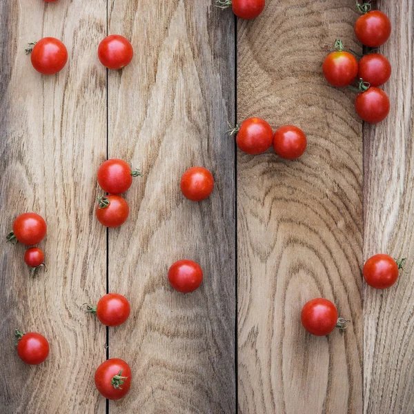 Tomates cereja e colher de madeira — Fotografia de Stock