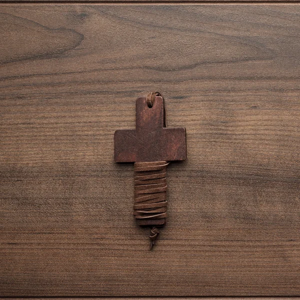 Cross over brown wooden background — Stock Photo, Image