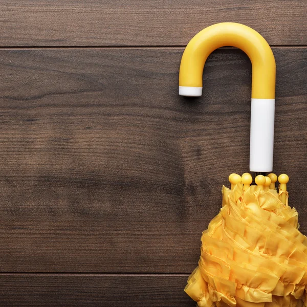 Folded yellow umbrella on the table — Stock Photo, Image