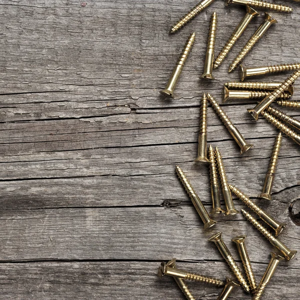 Yellow screws on the wooden table — Stock Photo, Image