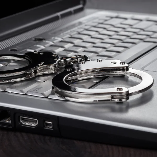 Handboeien op laptop cyber misdaad concept — Stockfoto
