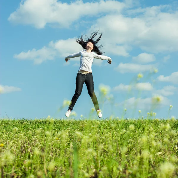 Jente hopper på jordet sommertid – stockfoto