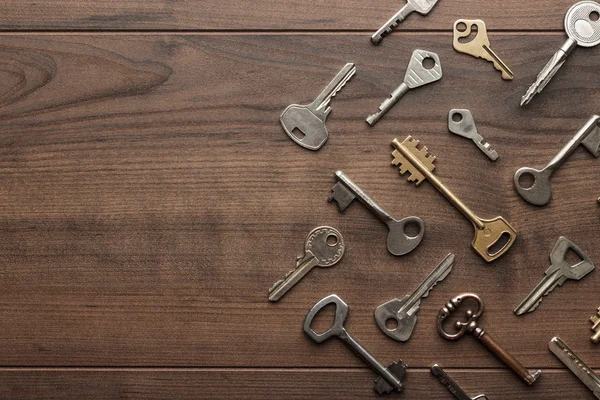 Много разных ключей на деревянном столе — стоковое фото