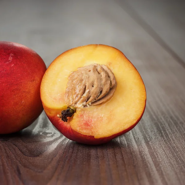 Alcune pesche noci fresche su fondo di legno — Foto Stock