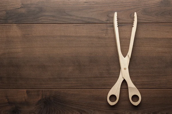 Wooden grill tongs on the table — Stock Photo, Image