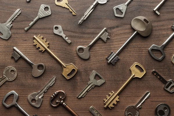 Många olika nycklar på träbord — Stockfoto