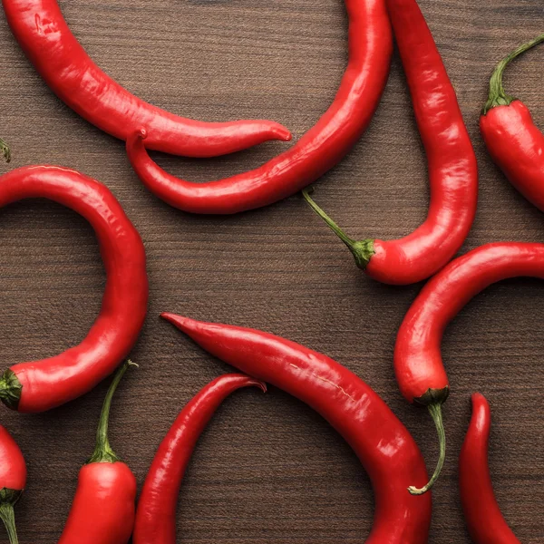 Red hot chilli papričky na dřevěný stůl — Stock fotografie