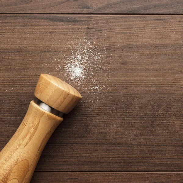 Agitador de sal de madera sobre la mesa — Foto de Stock