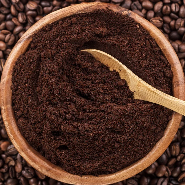 Chicchi di caffè e ciotola di legno piena di caffè macinato — Foto Stock