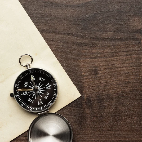 Kompass och gamla papper på den bruna träbord — Stockfoto