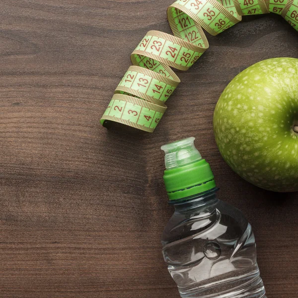 Fles water meten tape en verse groene appel — Stockfoto