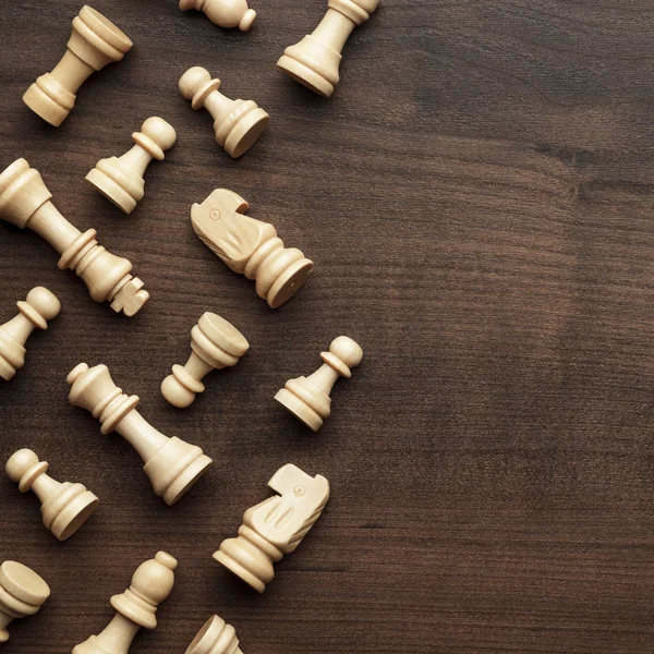 Chess siffror på brun träbord bakgrund — Stockfoto