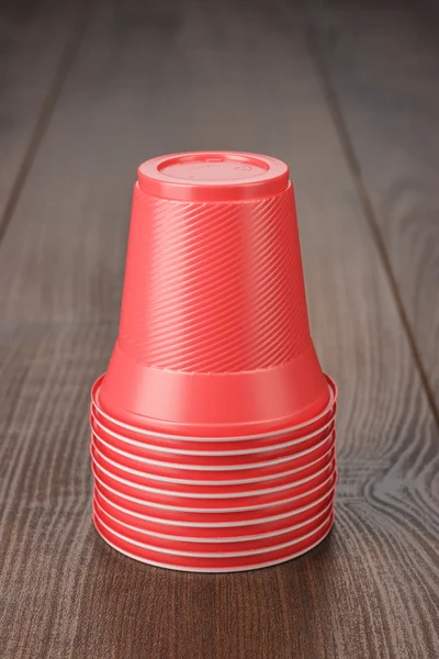 Stapel roter Plastikbecher auf dem Tisch — Stockfoto