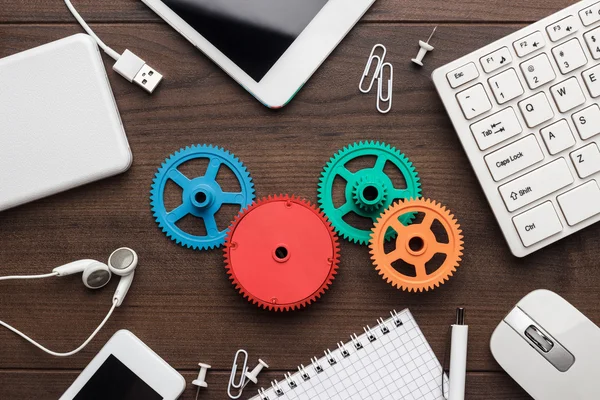 Flusso di lavoro e concetti di lavoro di squadra con ingranaggi colorati e diversi gadget — Foto Stock