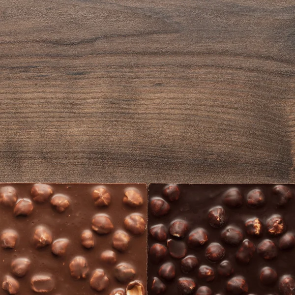 Different chocolate bars with whole hazelnuts — Stock Photo, Image