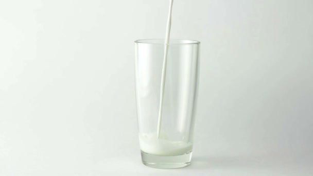Lait remplissant le verre sur fond blanc 