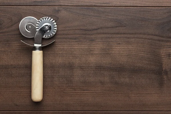 Cortador de pizza en la mesa de madera — Foto de Stock