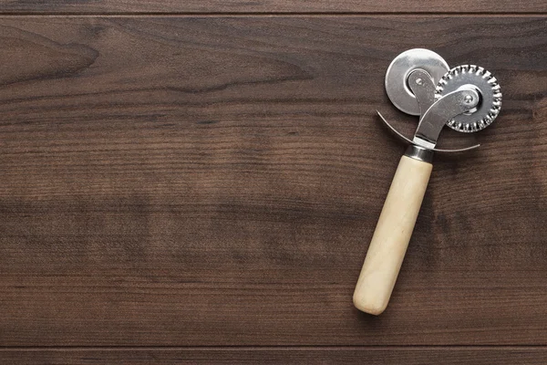 Pizza cutter op houten tafel — Stockfoto