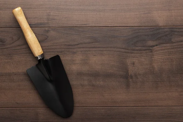 Черная лопата для садоводства на деревянном столе — стоковое фото